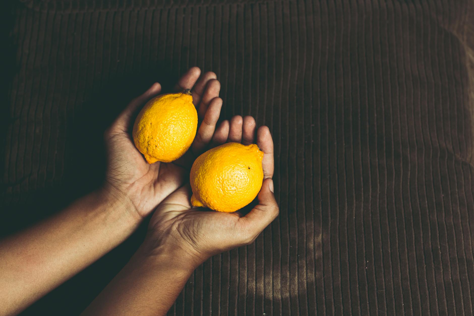 Two women smiling with lemon slices, expressing joy and vitality in midlife