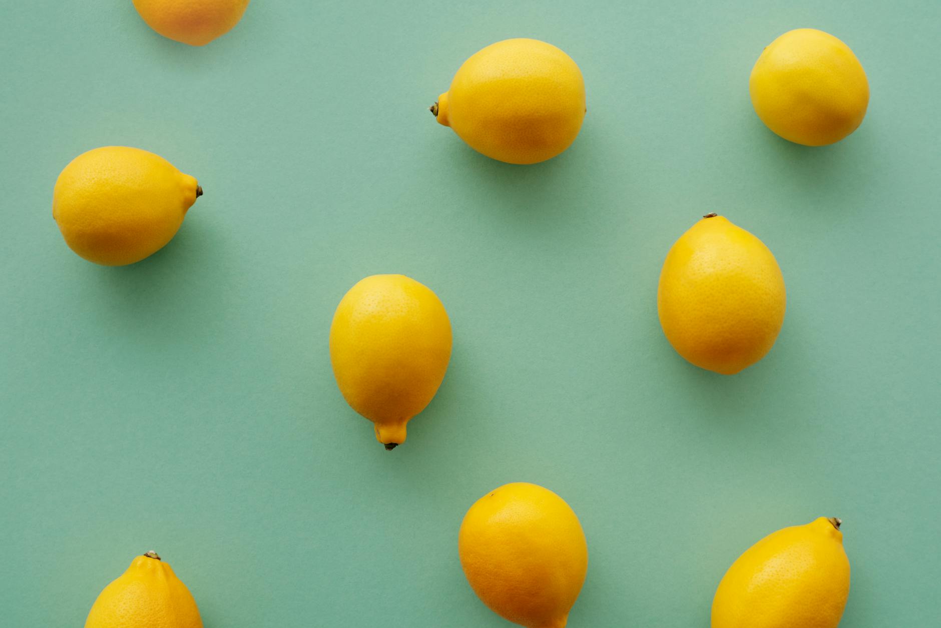Bright yellow lemons arranged on a pastel green background, symbolizing fresh communication and openness
